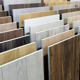 Flooring showroom displaying a wide selection of luxury vinyl plank, laminate, and engineered wood flooring samples in various colors and wood grain finishes.