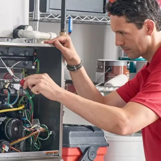 HVAC technician repairing residential furnace during professional heating system maintenance