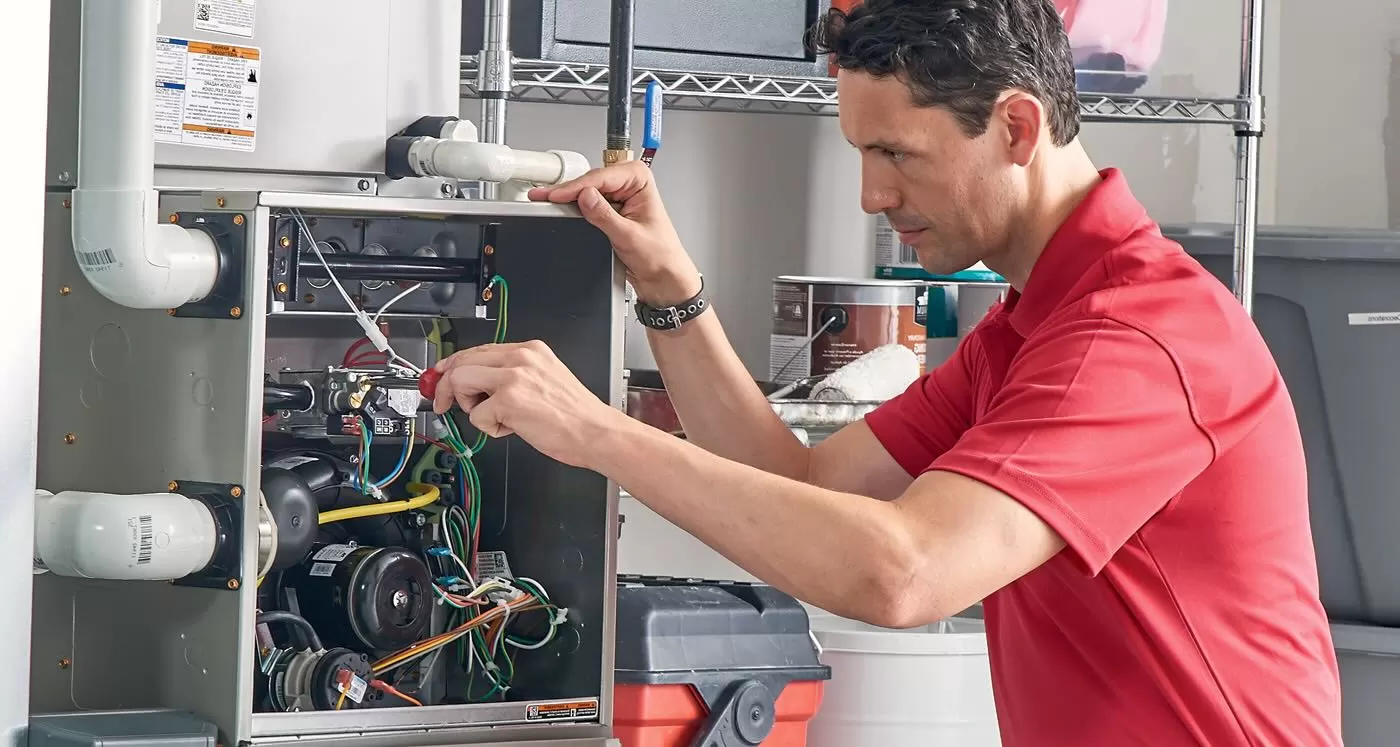 HVAC technician repairing residential furnace during professional heating system maintenance