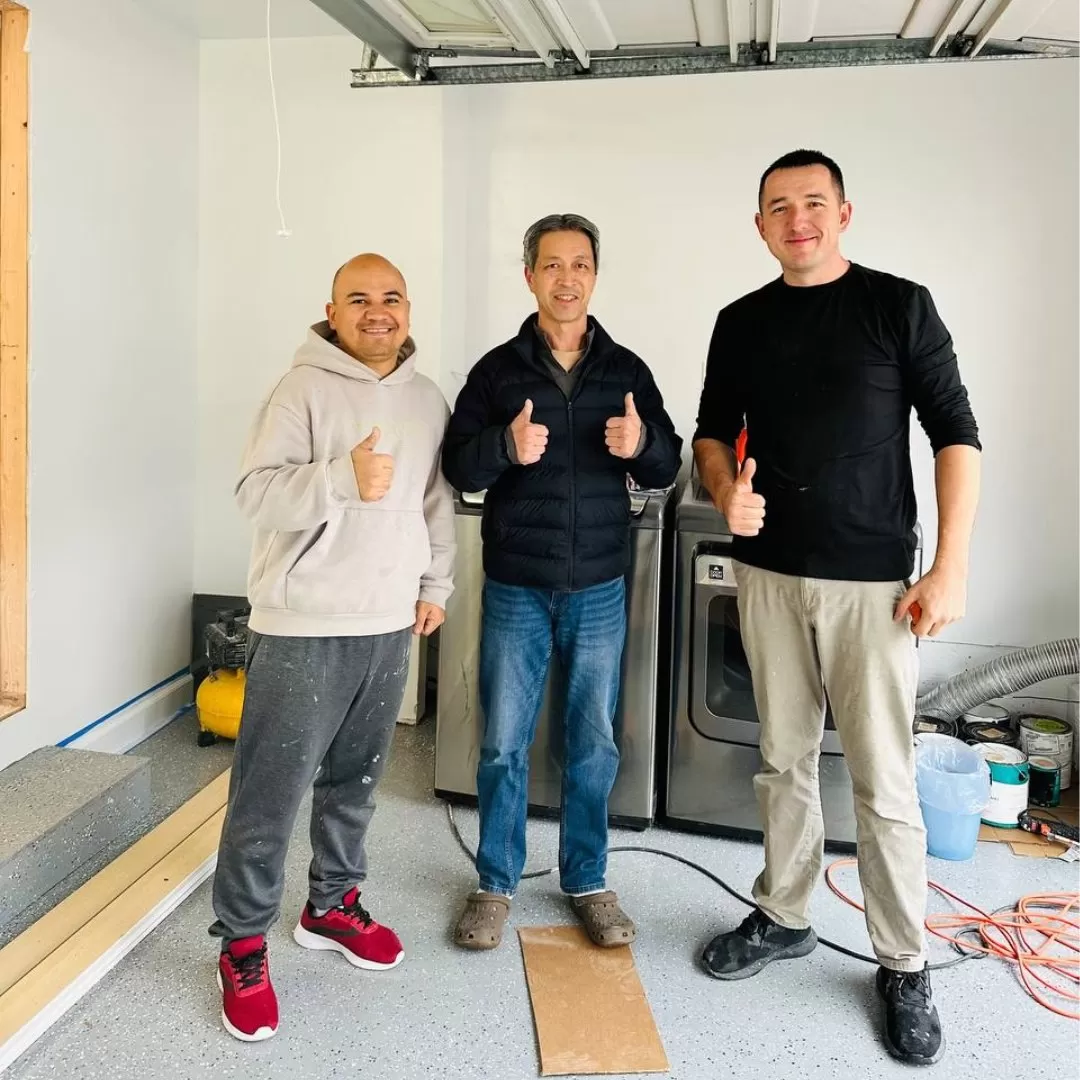 Happy homeowners with a handyman after completing a successful home remodeling project