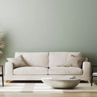Modern living room with a neutral sofa, accent chairs, minimalist décor, and freshly painted walls after an interior renovation