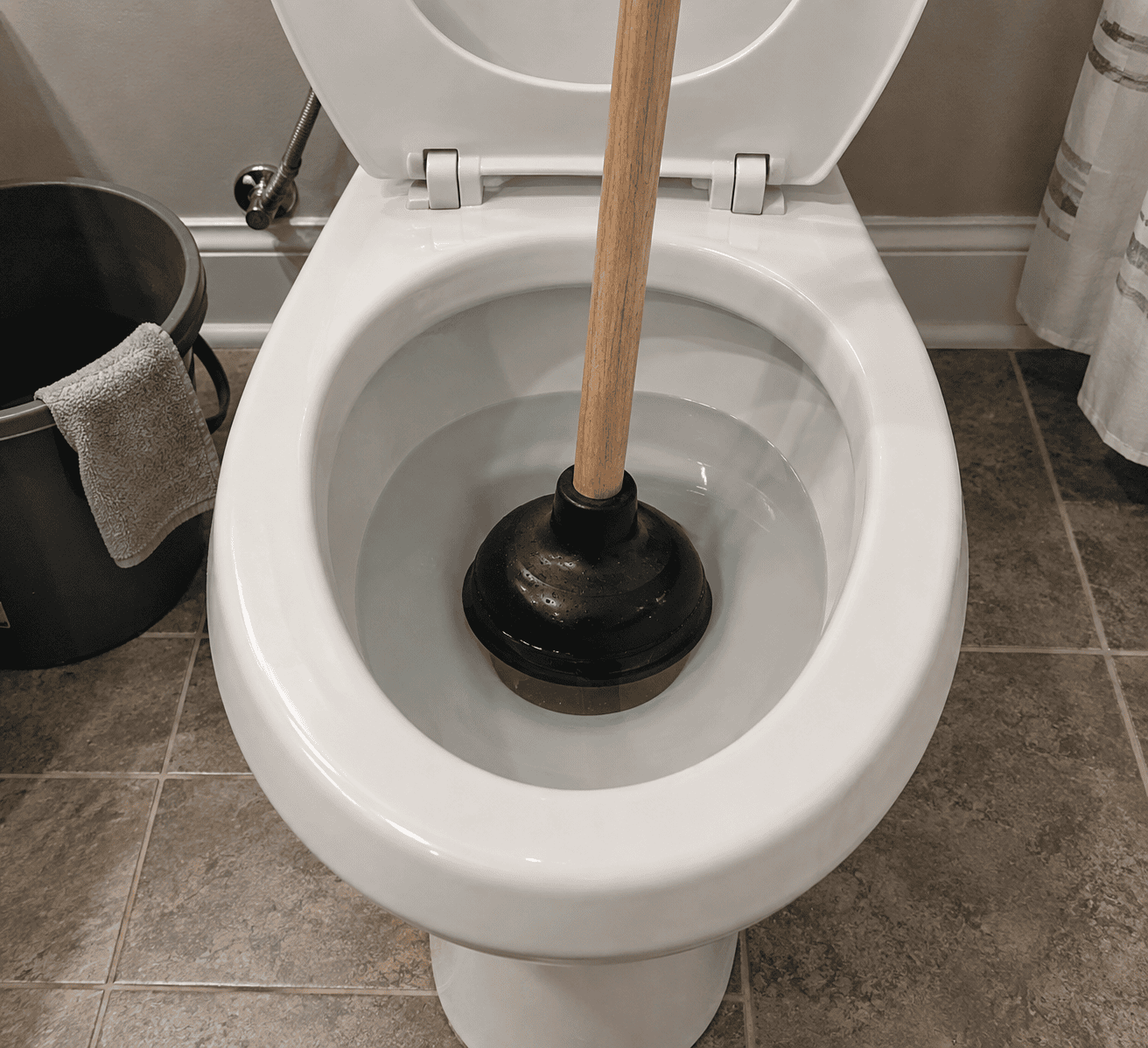 Flange plunger seated in a toilet bowl with water covering the rubber cup Flange plunger seated in a toilet bowl with water covering the rubber cup